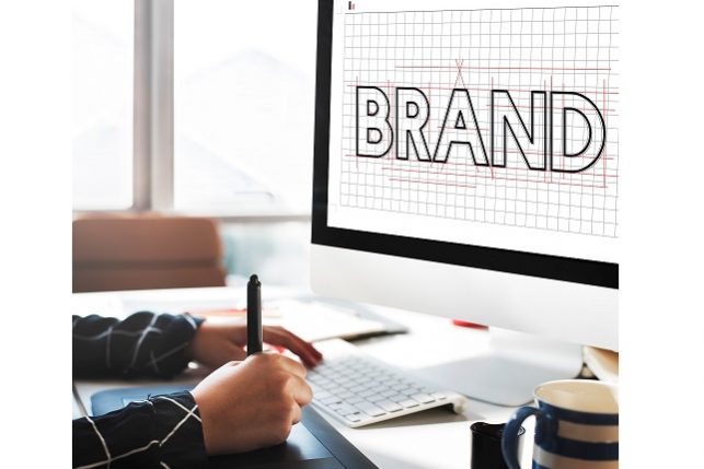 Photo of man drawing beside screen that reads "Brand" illustrates blog: "What Is a Brand Story (and Why It Matters)?"