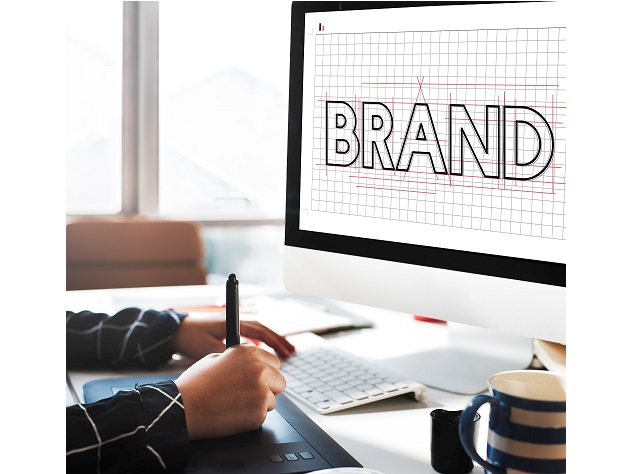 Photo of man drawing beside screen that reads "Brand" illustrates blog: "What Is a Brand Story (and Why It Matters)?"