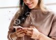 Photo of woman smiling looking at smartphone illustrates blog: "5 Books to Understand the Future of Digital Marketing"