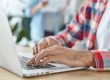 Photo of man in front of computer illustrates blog: "Technical SEO: a Basic Guide for Small Business Owners"