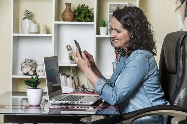 Photo of woman with smartphone and laptop illustrates blog: "The Trends That Shaped 2021 in 5 Google Searches"