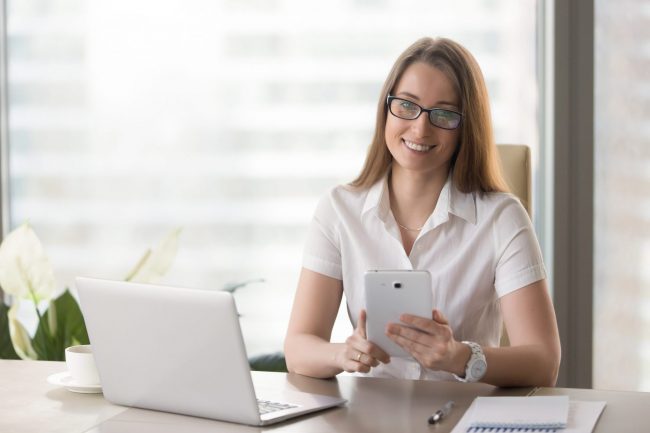 Photo of smiling woman in office illustrates blog: "7 Content Marketing Tips to Supercharge Your Sales in 2022"